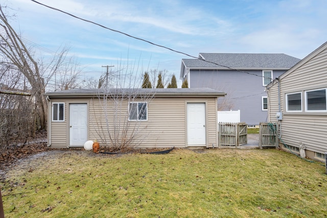 back of property featuring an outbuilding and a lawn