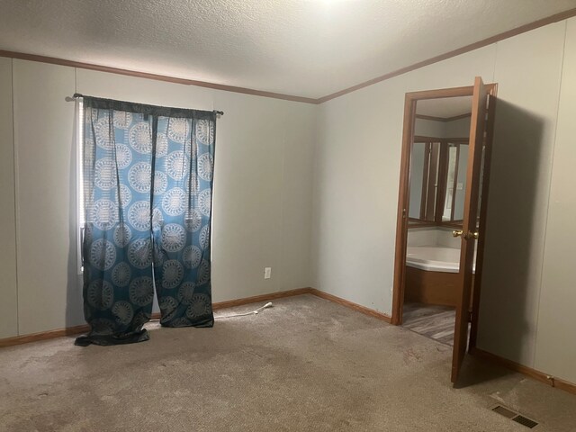 unfurnished bedroom with ornamental molding, carpet floors, and a textured ceiling