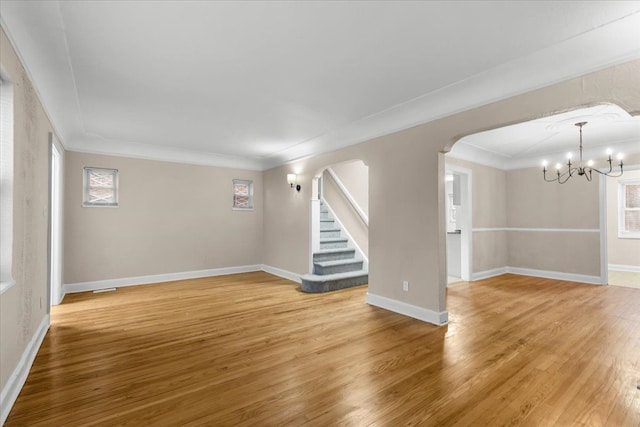 interior space with ornamental molding, hardwood / wood-style floors, and an inviting chandelier