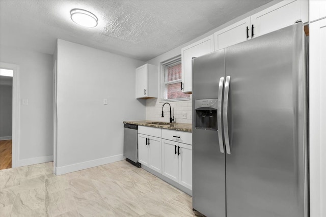 kitchen featuring stainless steel appliances, sink, dark stone countertops, white cabinets, and decorative backsplash