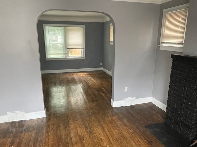 unfurnished room with crown molding and dark wood-type flooring