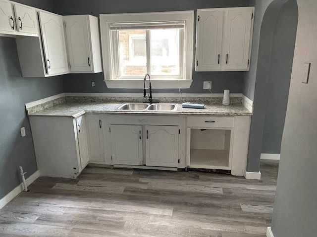 kitchen featuring sink, white cabinets, and light wood-type flooring