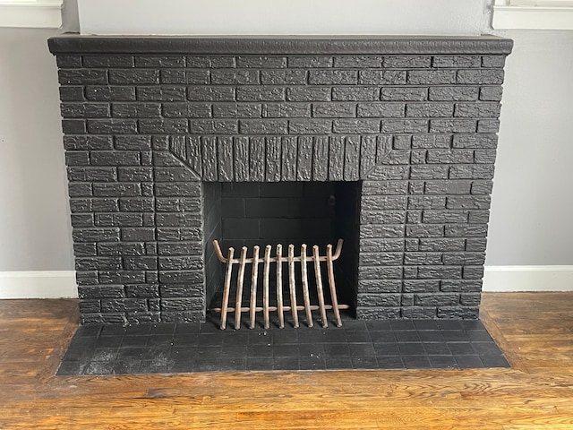 interior details featuring a brick fireplace and hardwood / wood-style flooring