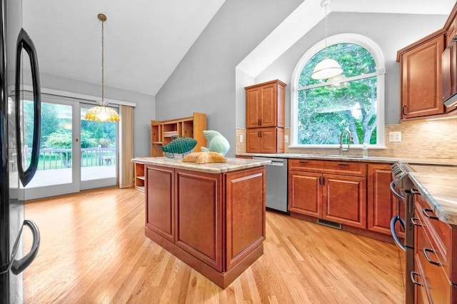 kitchen featuring pendant lighting, stainless steel appliances, a center island, and light hardwood / wood-style flooring