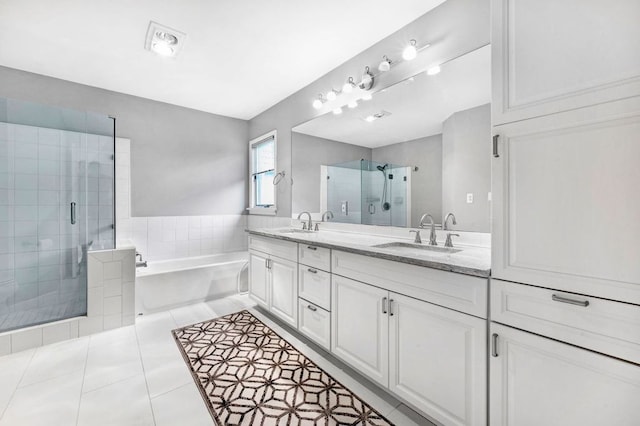 bathroom featuring independent shower and bath, vanity, and tile patterned flooring