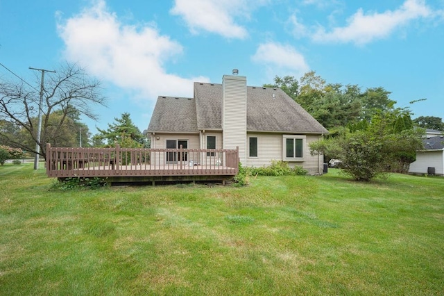 rear view of house featuring a yard and a deck