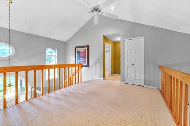 hallway featuring vaulted ceiling and light colored carpet