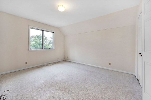 additional living space featuring light colored carpet and lofted ceiling