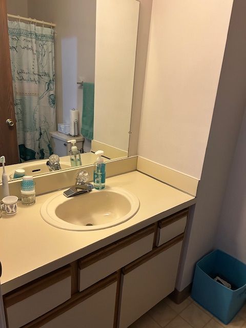 full bathroom featuring a shower with curtain, vanity, and tile patterned flooring