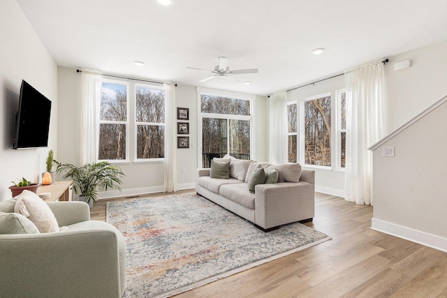 living room with ceiling fan and light hardwood / wood-style flooring