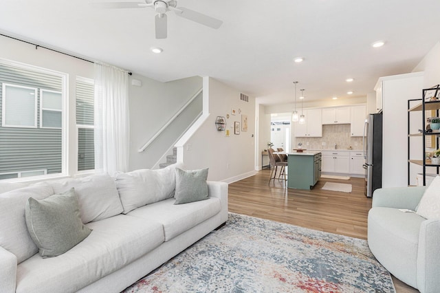 living room featuring ceiling fan and light hardwood / wood-style floors