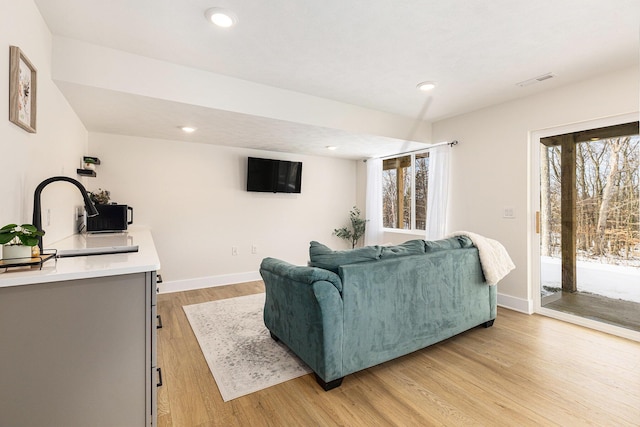living room featuring sink and light hardwood / wood-style floors