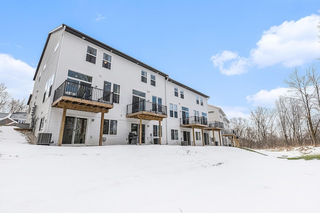 snow covered house featuring cooling unit