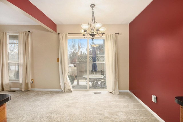 unfurnished dining area with a notable chandelier and carpet flooring