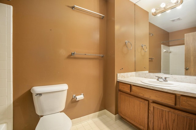 bathroom featuring vanity, a tile shower, tile patterned floors, and toilet