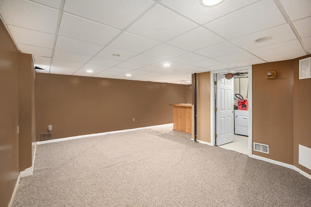 basement featuring light carpet and a paneled ceiling