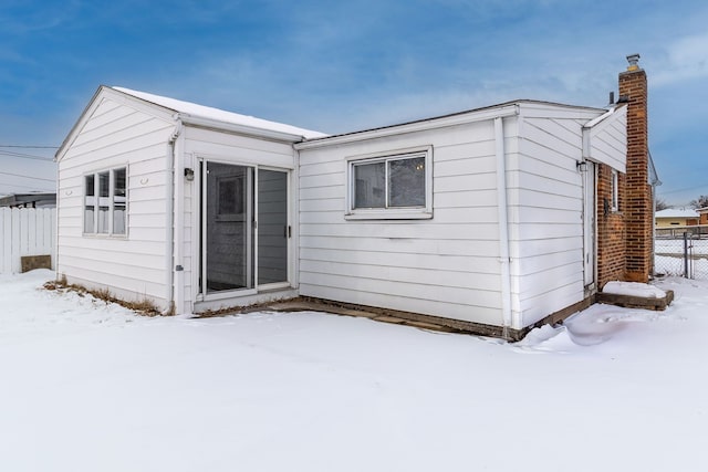 view of snow covered back of property