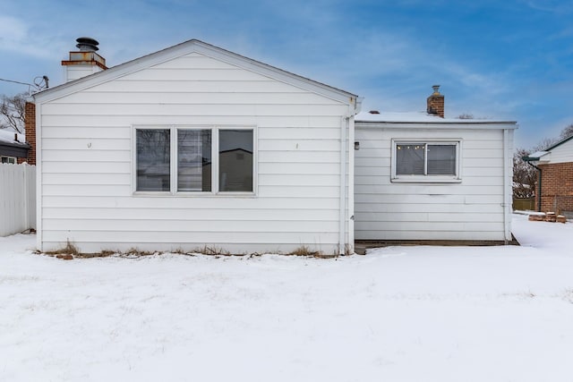 view of snow covered rear of property