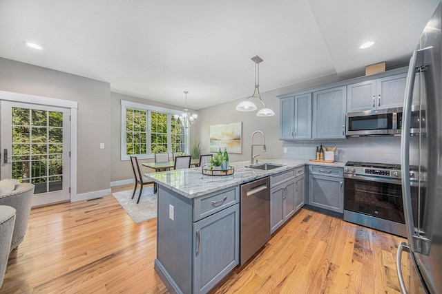 1115 Nature Trl, Manchester, MI 48158 - kitchen featuring sink, decorative light fixtures, appliances with stainless steel finishes, kitchen peninsula, and decorative backsplash