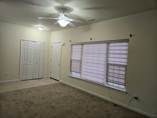 spare room featuring light colored carpet and ceiling fan