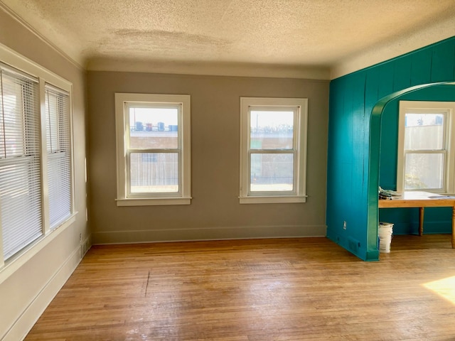 unfurnished room featuring a textured ceiling and light wood-type flooring