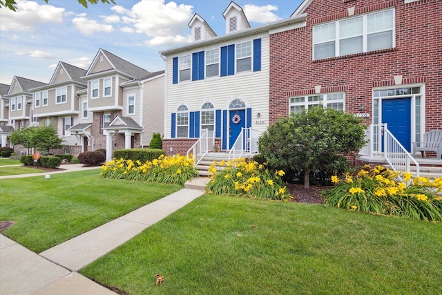 view of front of house with a residential view, a front lawn, and brick siding