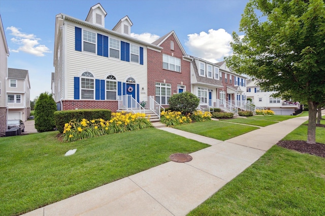 townhome / multi-family property with brick siding and a front lawn