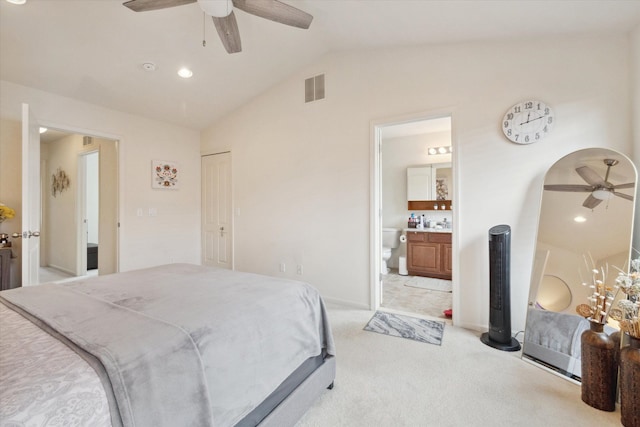 bedroom featuring arched walkways, lofted ceiling, visible vents, ensuite bathroom, and light carpet