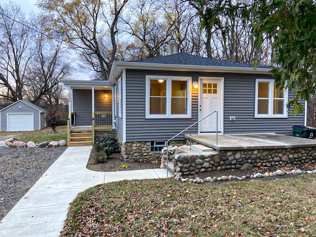 view of front facade with a garage, an outdoor structure, and covered porch