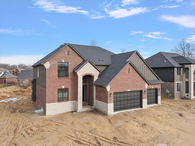 view of front of property featuring a garage, a shingled roof, board and batten siding, and brick siding