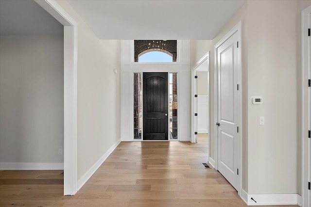 foyer featuring light wood-type flooring, visible vents, and baseboards