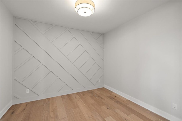 spare room with light wood-style floors and baseboards