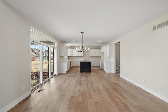 unfurnished living room featuring recessed lighting, light wood-type flooring, visible vents, and baseboards