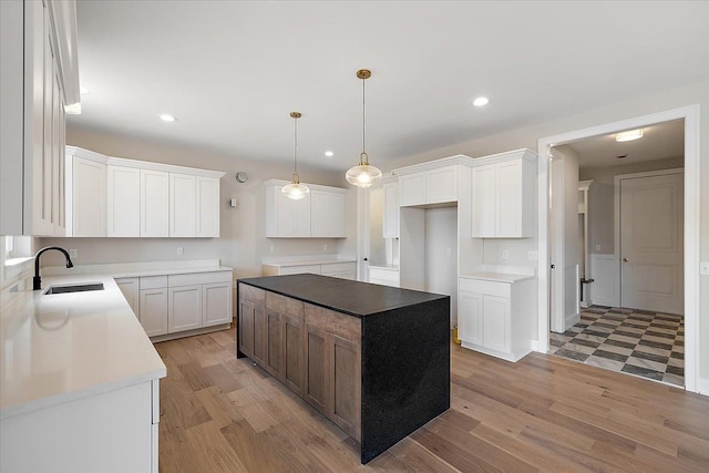 kitchen with light wood-type flooring, a sink, and recessed lighting