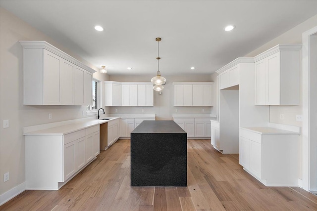 kitchen featuring recessed lighting, a sink, white cabinetry, light wood-type flooring, and dishwasher