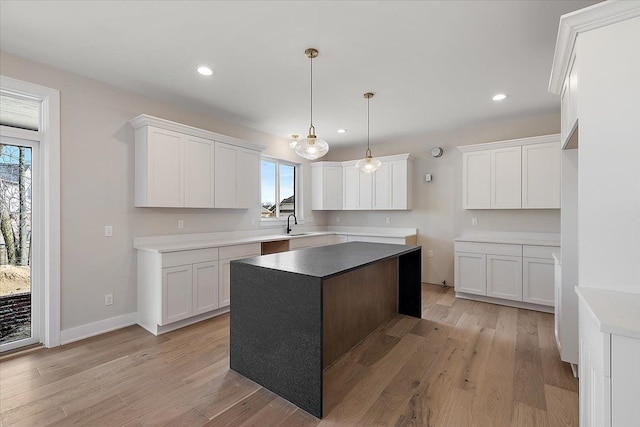 kitchen with light wood finished floors, white cabinets, and recessed lighting