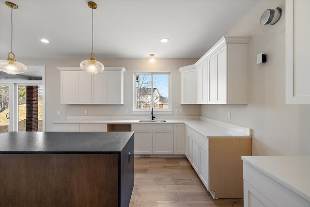 kitchen with a wealth of natural light, white cabinetry, a sink, and recessed lighting