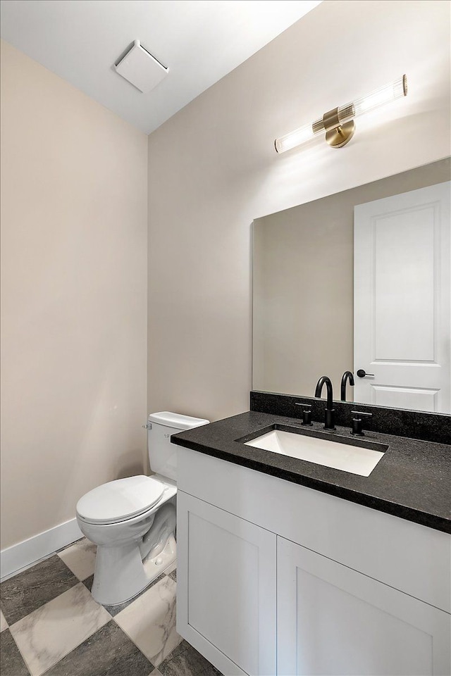 bathroom with vanity, toilet, and baseboards