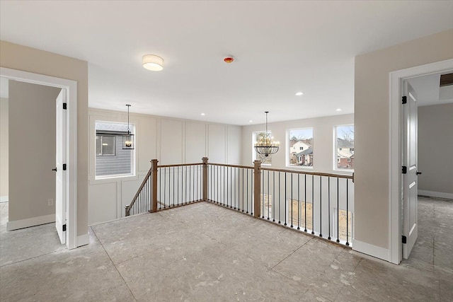 spare room with baseboards, recessed lighting, and a notable chandelier