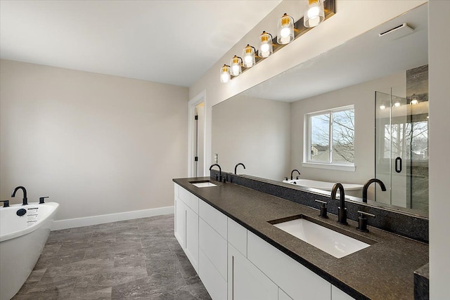 bathroom featuring a soaking tub, a sink, a shower stall, and baseboards