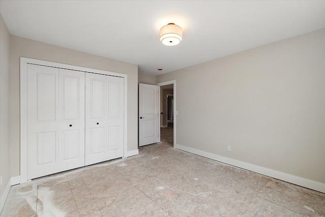 unfurnished bedroom featuring a closet and baseboards