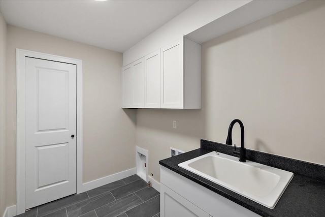 laundry area with cabinet space, baseboards, a sink, washer hookup, and electric dryer hookup