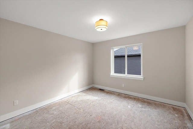 unfurnished room with baseboards