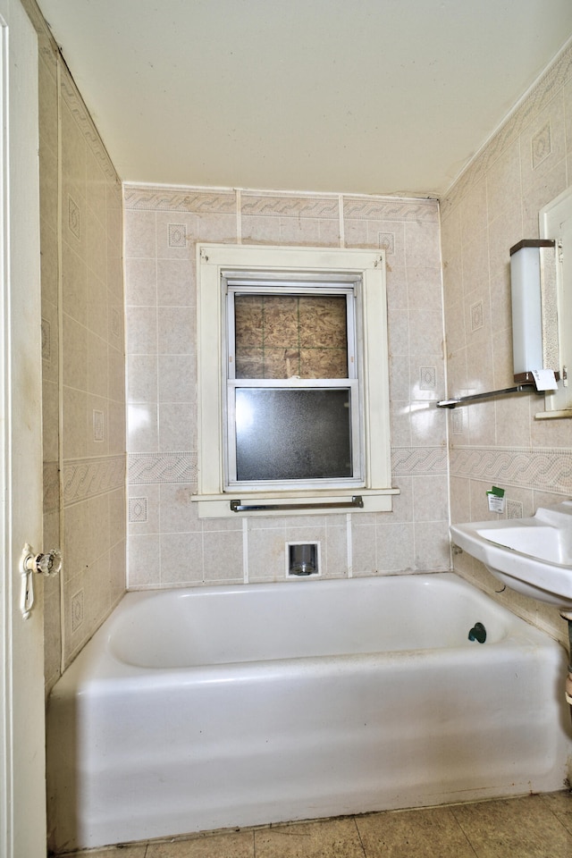 bathroom with tile walls, tile patterned floors, and a bathing tub