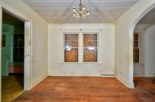 unfurnished dining area with dark hardwood / wood-style flooring and an inviting chandelier