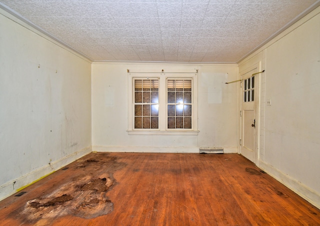 unfurnished room with hardwood / wood-style flooring and ornamental molding