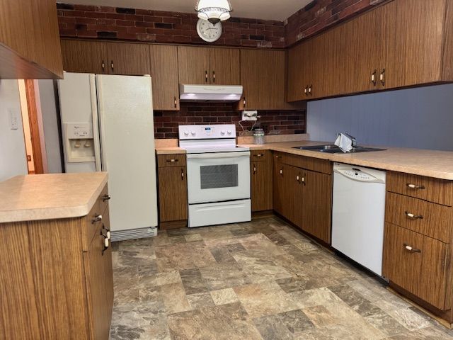 kitchen with white appliances, sink, and backsplash