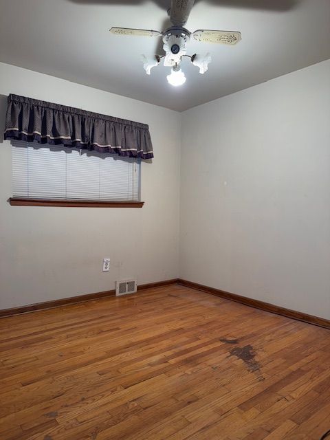 empty room featuring hardwood / wood-style flooring and ceiling fan