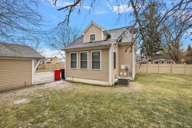 back of property featuring a yard and central air condition unit