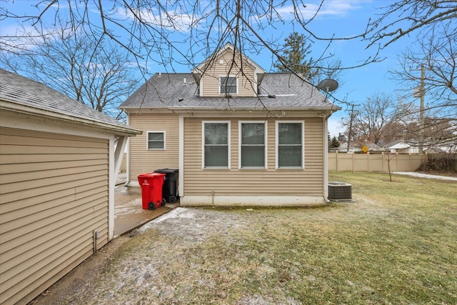 back of house with central AC and a yard